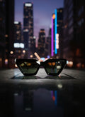 aruba noir black cat eye sunglasses with a night-time city background